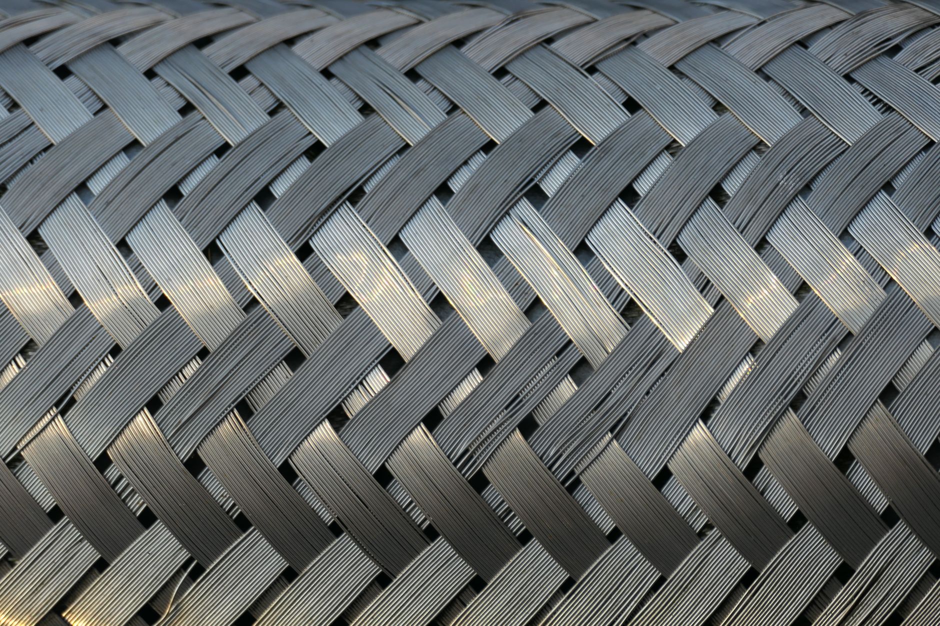 Detailed view of a metallic mesh with interwoven strands, showcasing industrial design and texture.
