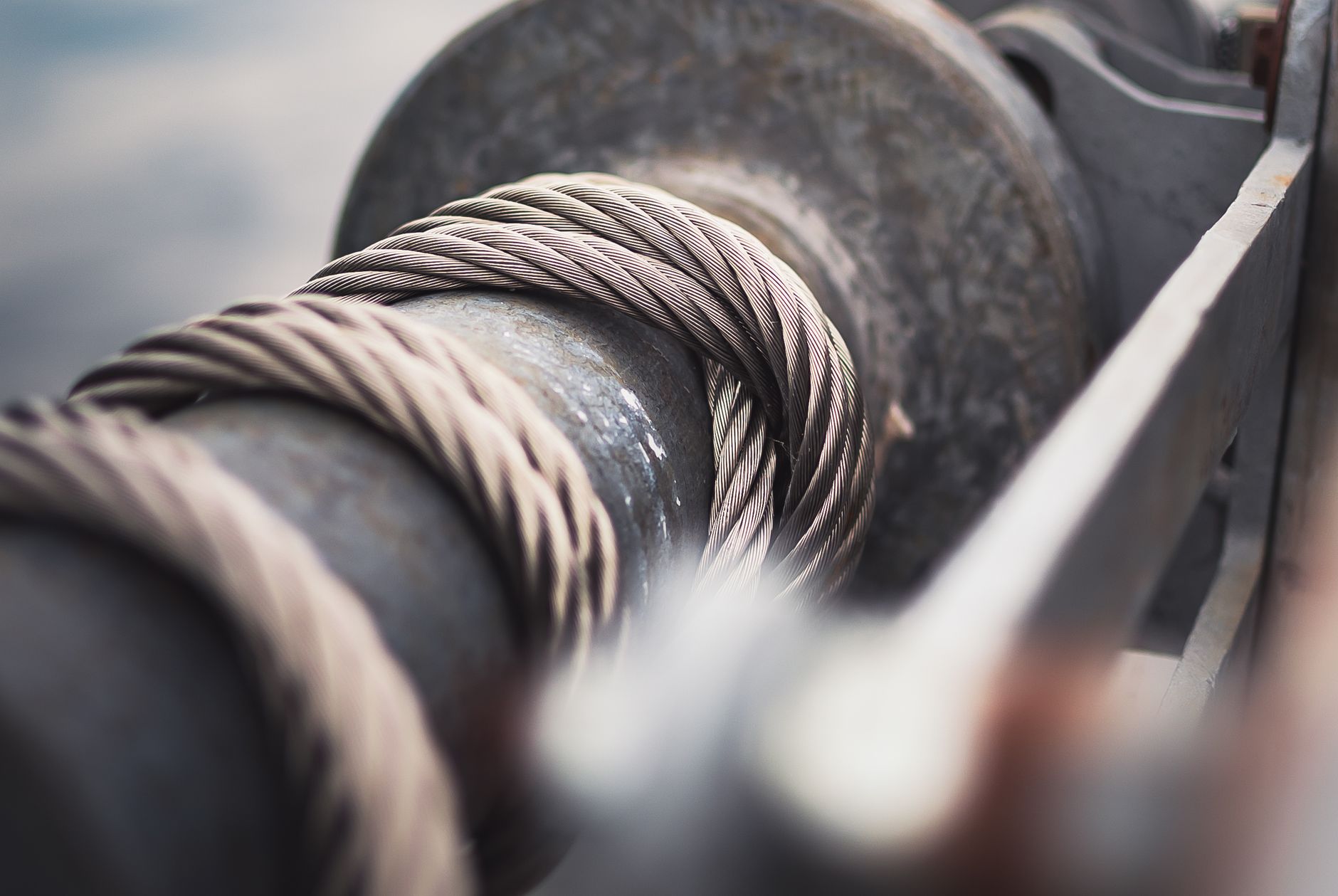 Detailed view of a strong steel cable wrapped around a mechanical reel, showcasing industrial strength.